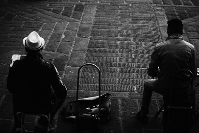 Rear view of men sitting on street