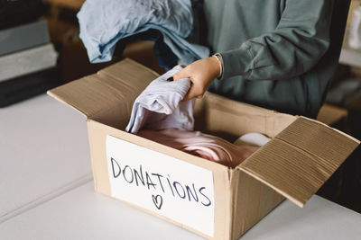 Volunteer teengirl preparing donation boxes for people.