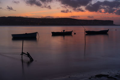 Fishing boats on a river sea at sunset in foz do arelho, portugal