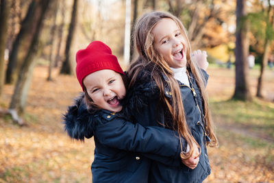 Portrait of happy siblings standing in park