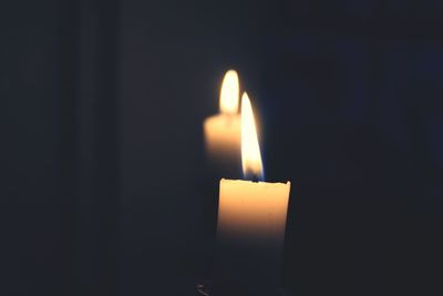 Close-up of lit candle in dark room