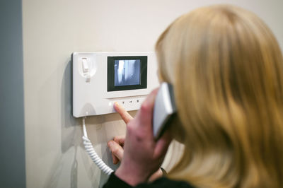 Close-up of woman talking on intercom