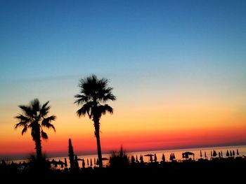 Silhouette palm trees against sky during sunset