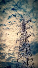 Low angle view of power lines against cloudy sky