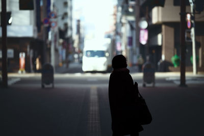 Rear view of woman walking on street