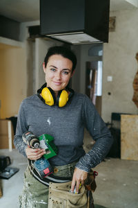 Portrait of smiling female construction manager with equipment at construction site