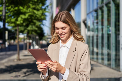 Portrait of young woman using digital tablet