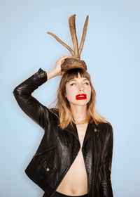 Portrait of woman standing against black background