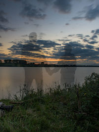 Scenic view of lake against cloudy sky