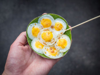 Cropped image of person holding fried quail eggs at amphawa floating market, thailand