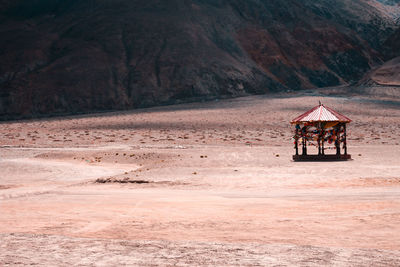 Lifeguard hut on field against mountain