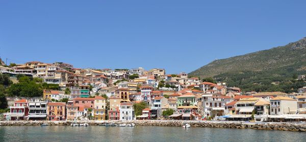 Houses by town against clear blue sky