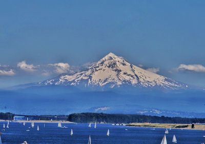Scenic view of snowcapped mountains by sea against sky
