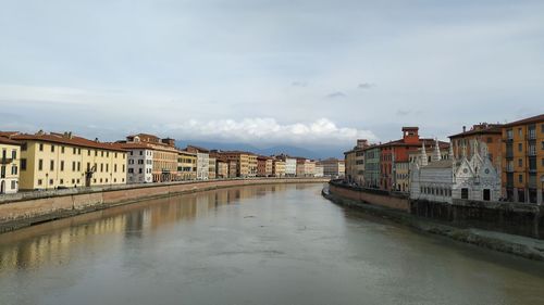 Canal amidst buildings in city against sky