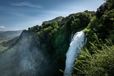 Scenic view of waterfall against sky