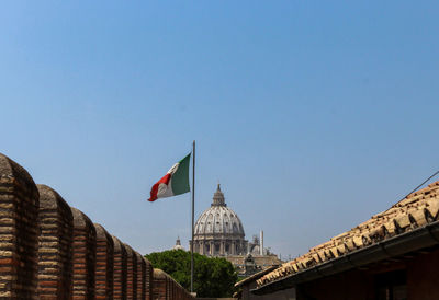 Low angle view of flags against clear blue sky