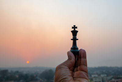 Cropped hand of woman holding chess piece