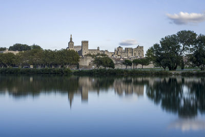 Scenic view of lake by buildings against sky