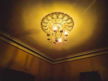 Low angle view of illuminated pendant lights hanging from ceiling