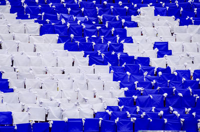 Crowd wearing gloves holding blue and white fabrics