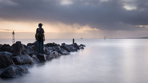 Full length of man standing on groyne