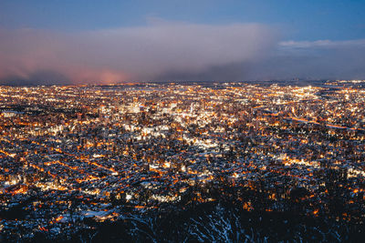 High angle view of illuminated cityscape against sky at night