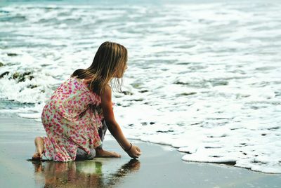 Rear view of a girl overlooking calm sea