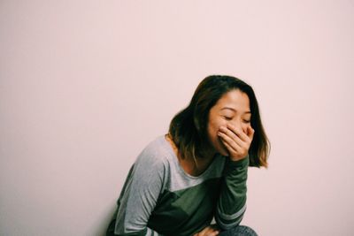 Young woman standing against the wall