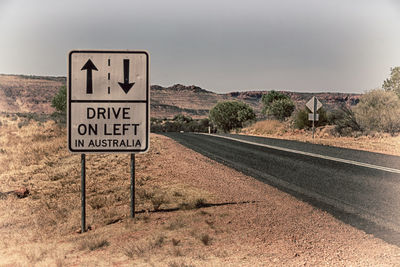 Information sign on road against sky