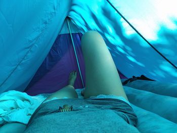 Low section of woman lying in tent