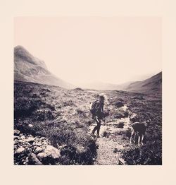 Silhouette men on landscape against mountains