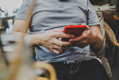 Midsection of man using mobile phone