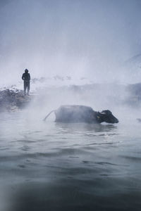 Man standing on sea against sky