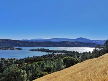 Clearlake against blue mountain background and golden grasses.