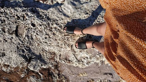 Low section of woman standing on rock