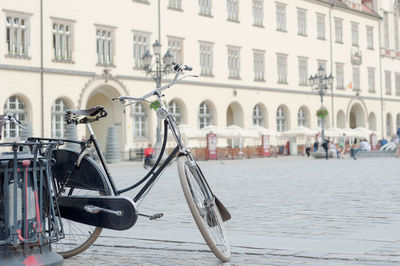 Bicycle parked on street by building in city