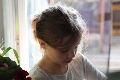 Close-up portrait of girl looking at home