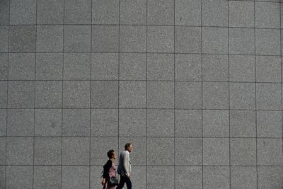 People walking in front of wall
