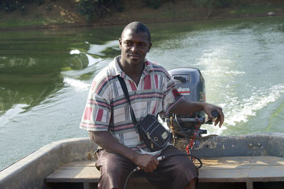 Portrait of man sitting on boat in river