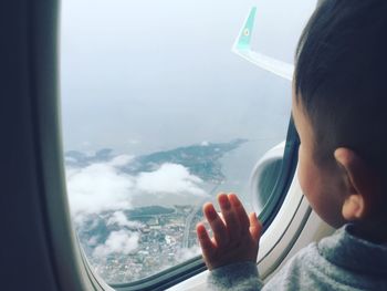 Close-up of man in airplane against sky