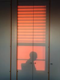 Shadow of person on closed door at home