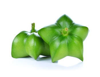 Close-up of green fruit against white background