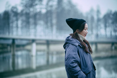 Side view of man standing in rain during winter