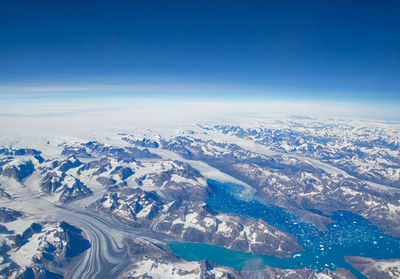 Scenic view of snowcapped mountains against blue sky