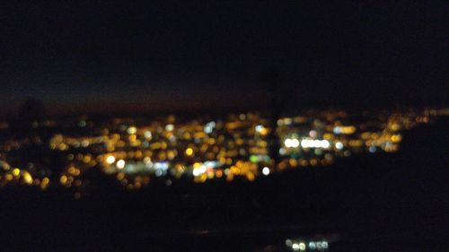 Illuminated cityscape against sky at night