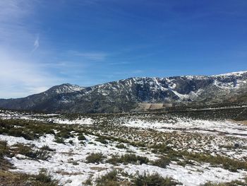 Scenic view of snowcapped mountains and landscape against sky