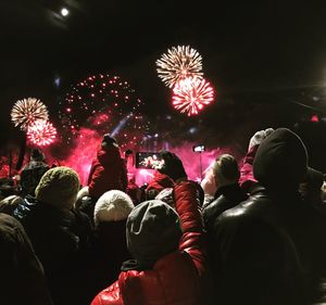 People watching firework display at night