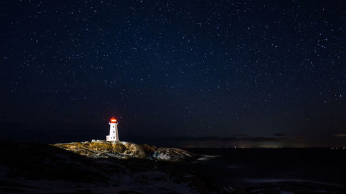 Lighthouse against sky at night