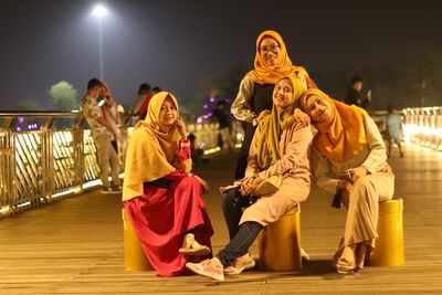 Rear view of people sitting at illuminated stage