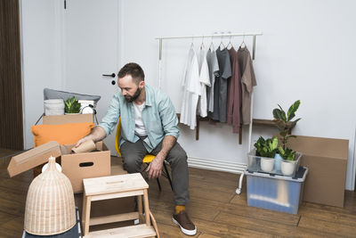 Mature man unpacking things from boxes while moving in new apartment.